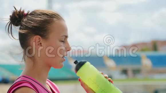 女运动员在体育场喝水特写镜头视频的预览图