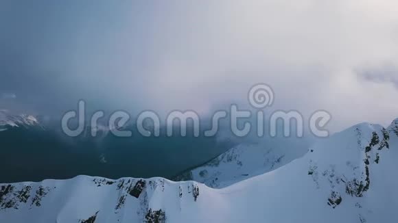 高耸的山峰被白色的雪覆盖着周围是雾视频的预览图