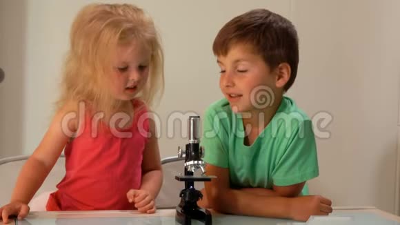 小女孩看着显微镜视频的预览图
