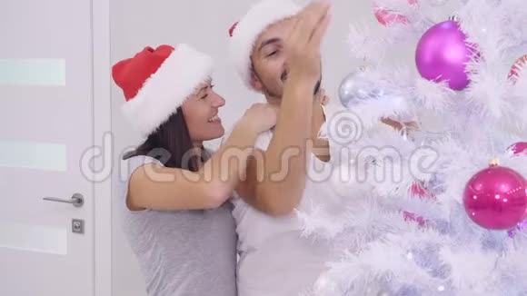 冬季寒冷的新年夜晚装饰圣诞树的性感情侣室内视频视频的预览图