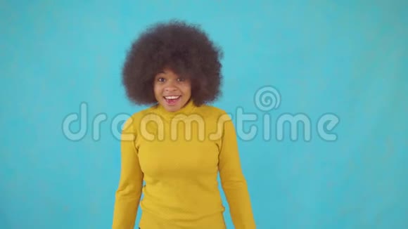 一位身穿黄色夹克的非洲发型富有表现力的非洲女人她懂得如何赢得比赛和跳舞视频的预览图