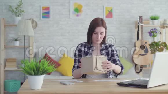 年轻女子把礼物包起来坐在桌旁慢悠悠视频的预览图