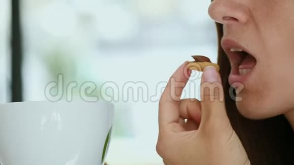 年轻女子喝着早咖啡饼干视频的预览图