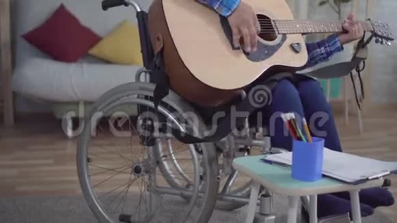 残疾的非裔美国妇女头发是非洲的坐在轮椅上弹着吉他视频的预览图