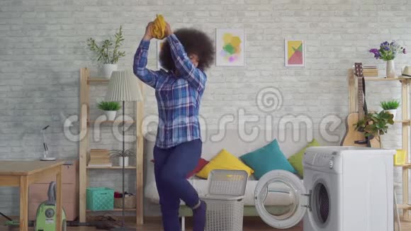 有非洲发型的快乐非洲女人把脏衣服扔到洗衣机里就像篮子里的一个球一样慢视频的预览图