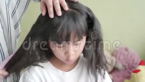 亚洲家庭的母亲给她的小女儿梳头视频的预览图