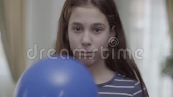 肖像漂亮的女孩躲在蓝色气球后面上面画着一张悲伤的脸然后把它放下这孩子不快乐视频的预览图