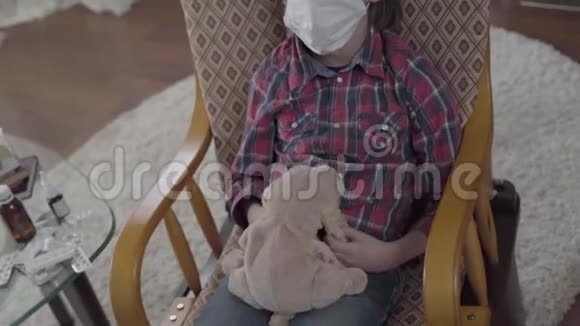 桌子上的药片药糖浆和带米色狗玩具的摇椅上戴着面具的孩子视频的预览图