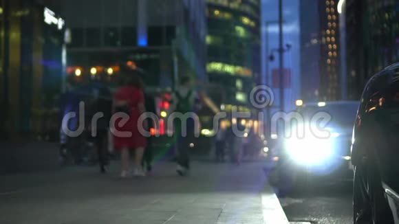 汽车的大灯照亮了人们行走的部分人行道视频的预览图