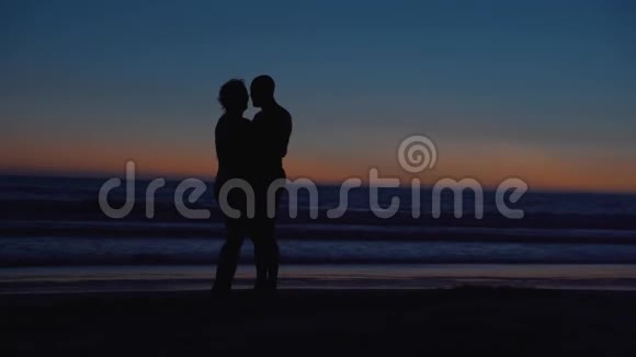 夏日夕阳西下岸边海洋上幸福的情侣视频的预览图