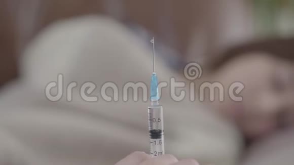 护士用注射器喷洒药物准备在前景中注射年轻女子身材模糊视频的预览图