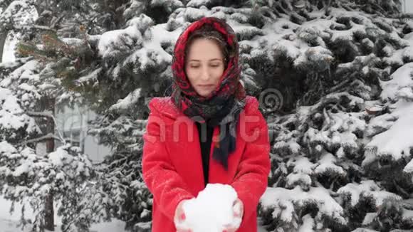 这段视频是关于美丽的年轻白种人穿着红色外套在冬季户外玩雪视频的预览图