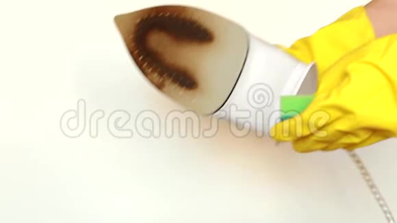 戴着黄色手套的女性手用海绵擦去铁的脏表面视频视频的预览图