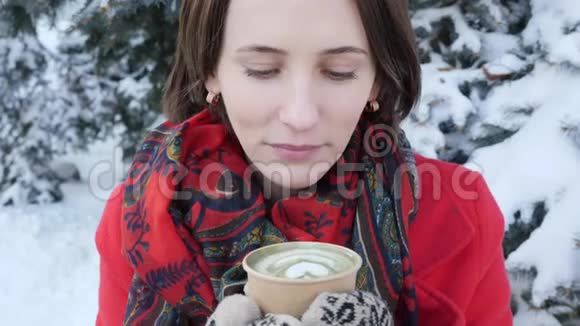 这个视频是关于一个女孩的脸特写她在冬天在街上吹热茶她穿针织手套什么视频的预览图