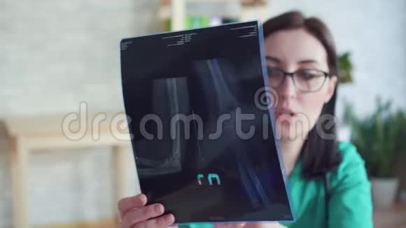 手拿x光的贴身女医生与病人沟通视频的预览图