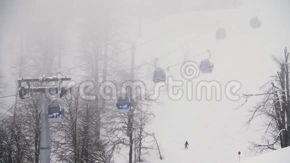 冬季森林中的圆形铁路航空山地滑雪场库存录像人们在山下滑雪视频的预览图