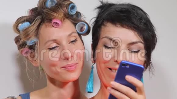 两个女孩在聚会上看着智能手机屏幕高兴起来视频的预览图