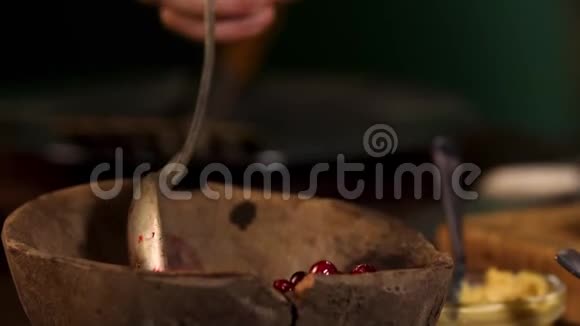 木制的旧碗和蔓越莓站在桌子上黑暗的房间背景库存录像把男性的手收起来视频的预览图