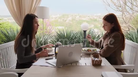两个女孩讨论她们的工作吃沙拉和喝茶视频的预览图