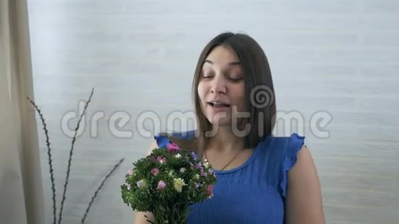 一位年轻的孕妇嗅着一朵花过敏视频的预览图