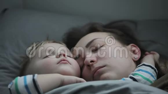 一个小男孩和他的母亲睡在一个拥抱视频的预览图