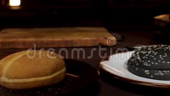 汉堡包在盘子上站在木桌上在黑暗的房间然后咕咕加工库存录像黑白的视频的预览图