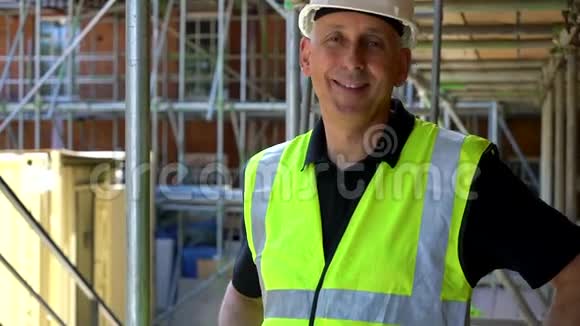 建筑工地的男建筑工人张开双臂微笑视频的预览图