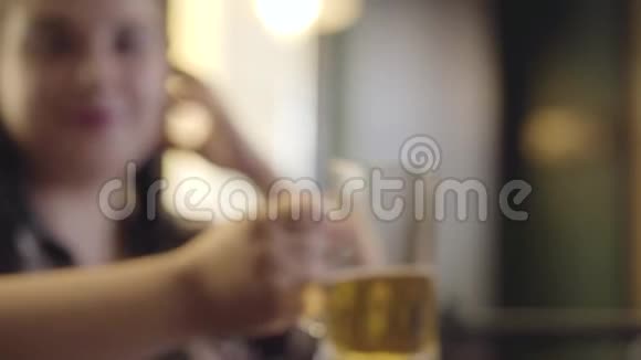 一个梳着辫子端着一杯啤酒坐在柜台前的女人模糊的身影那个女孩砰地一声响了半个空视频的预览图