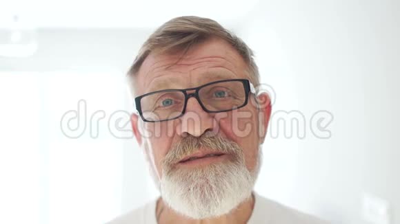 一位笑得开心的老人戴着眼镜和胡子的亲密肖像好爷爷父亲节视频的预览图