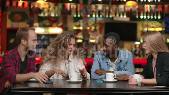 一家由朋友组成的跨国公司在餐馆里喝咖啡和聊天四个朋友聊天视频的预览图