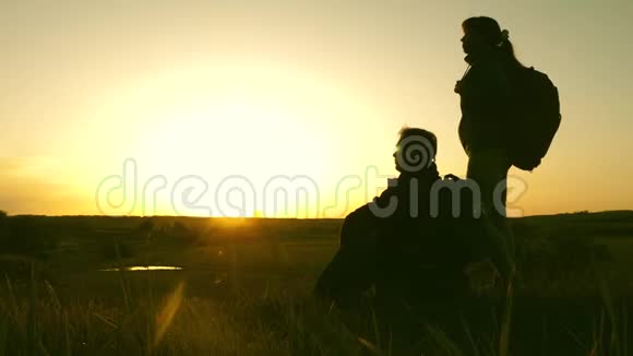 山顶上的旅行者男女在日落时欣赏风景情侣旅行者带着背包旅行Hik女孩视频的预览图