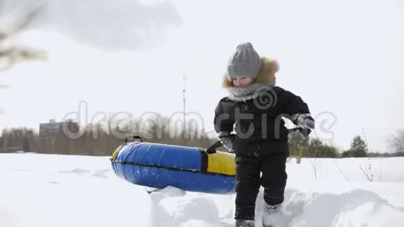 在冬天的公园里小男孩在雪地里走着拉油管视频的预览图