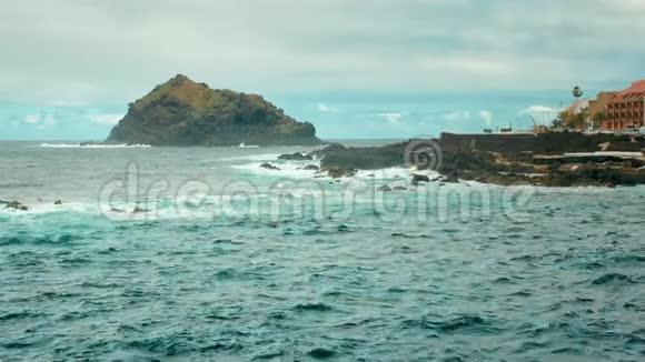 加那利群岛西部的海湾大海中的一块大石头海浪拍打着白色泡沫的石头视频的预览图