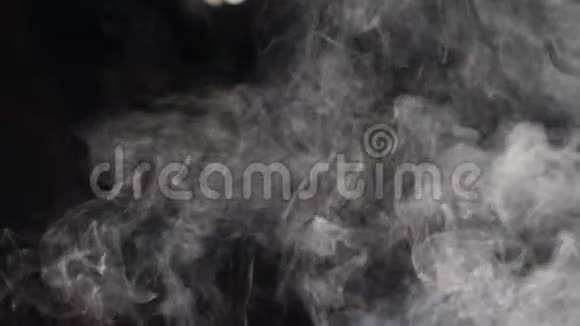 白色蒸汽在黑色背景上飞越潘白色蒸汽从幕后的大锅中升起慢慢视频的预览图
