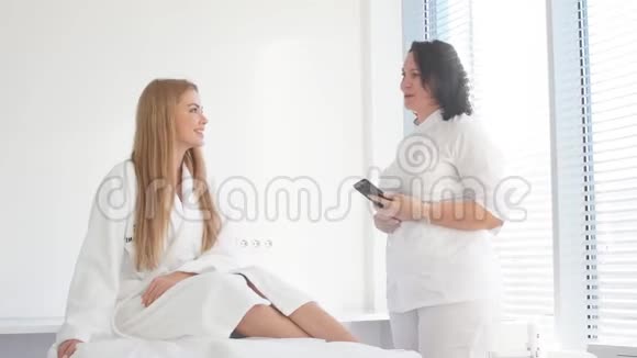 漂亮的女性客户向美容师咨询她即将进行的手术视频的预览图