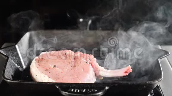 厨师用平底锅在黑色背景下烹饪炒肉牛排蒸汽从盘子中缓慢上升食物大师级食物视频的预览图