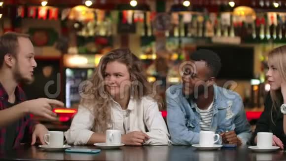一个穿衬衫的男人给朋友讲故事两个女孩和一个非裔美国人在听和笑一组视频的预览图