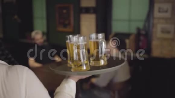 在一家啤酒餐馆里一个胖胖的胖女孩托盘上放着三杯啤酒女服务员给两个人带来啤酒视频的预览图