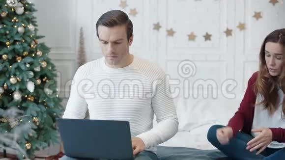 咄咄逼人的年轻女子阻碍男子在远程工作场所使用计算机视频的预览图