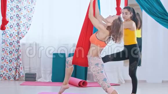 两个女人在工作室接受空中瑜伽训练视频的预览图