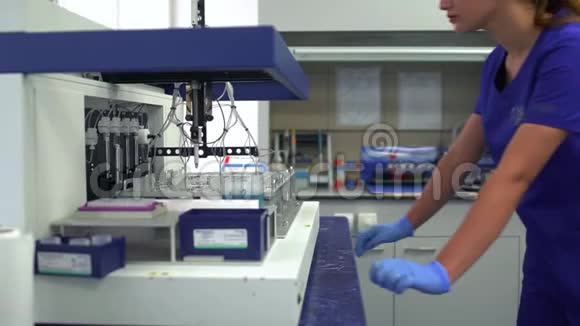 肖像年轻妇女穿着蓝色制服戴着橡胶手套控制实验室药品生产实验室测试视频的预览图