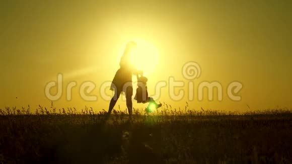妈妈在阳光下和女儿玩父母和小女儿玩快乐的孩子和他的母亲在公园散步视频的预览图