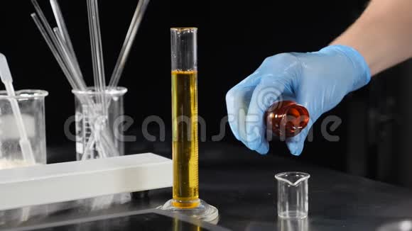 小型私人实验室生产化妆品手套将彩色液体缓慢倒入玻璃瓶中视频的预览图