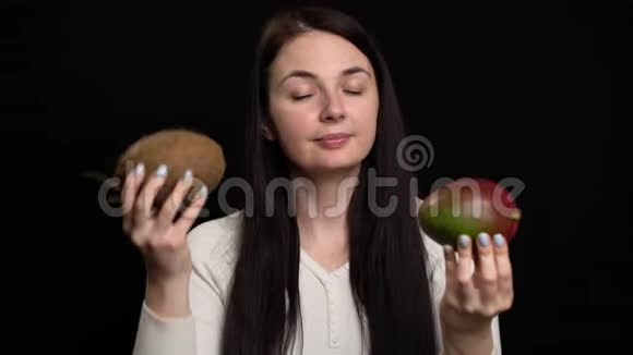 女人在黑色背景下展示椰子和芒果视频的预览图
