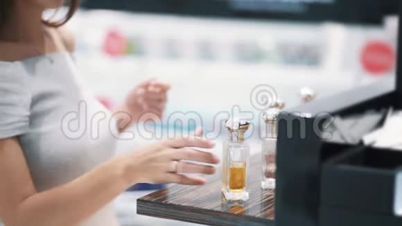 在橱窗里的香水女买家拿着它闻着慢动作视频的预览图