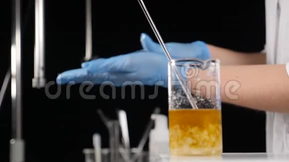 现代实验室理念黑色背景上带有彩色溶液的玻璃瓶蓝手套擦拭专家视频的预览图