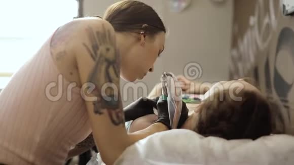 掌握在沙龙中使用纹身机为女性制作纹身侧视视频的预览图