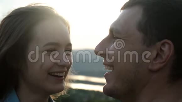 一对年轻夫妇在日落时享受乐趣和接吻的慢动作视频的预览图