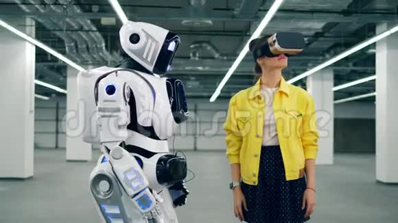 戴着VR眼镜的女人摸着白色机器人手视频的预览图