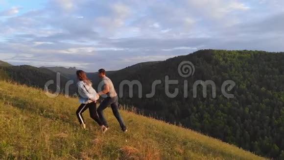 一对年轻夫妇沿着一条山路快乐地奔跑视频的预览图
